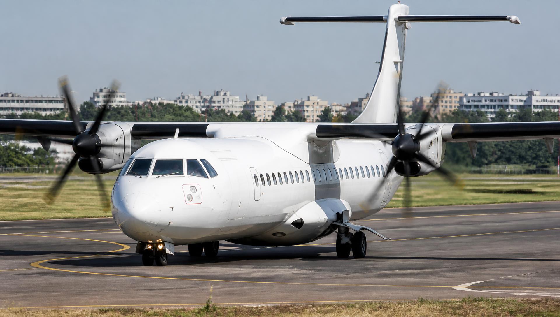 ATR turboprops taxiing on an airport taxiway in daylight