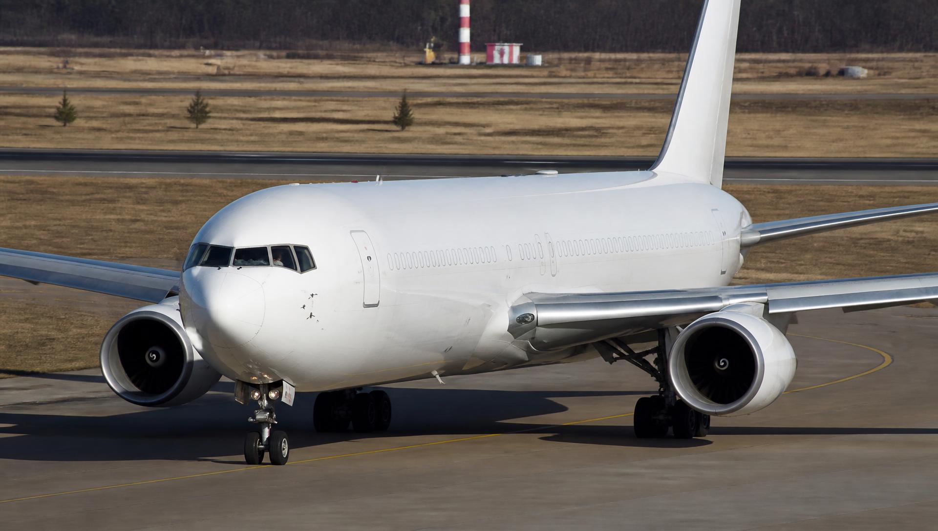 Boeing 767 taxiing on an airport taxiway in daylight