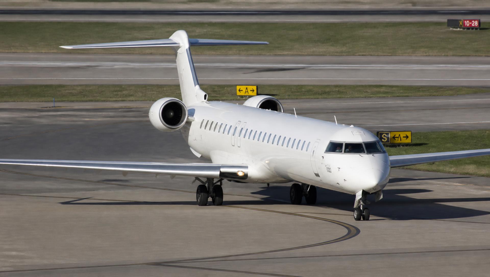 Bombardier CRJ taxiing on an airport taxiway in daylight